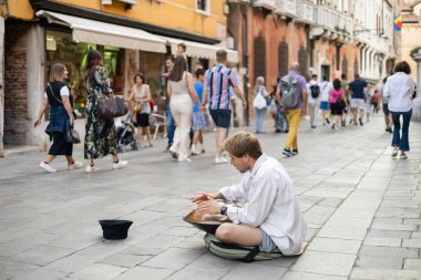 VENICE, ITALY - MAY 22, 2022: Street musician playing hang near hat on urban street 