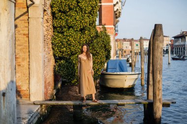Pregnant woman standing on pier on street in Venice 