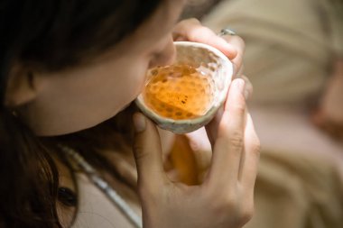 Ormanda çay içen bulanık bir kadının yüksek açılı görüntüsü. 