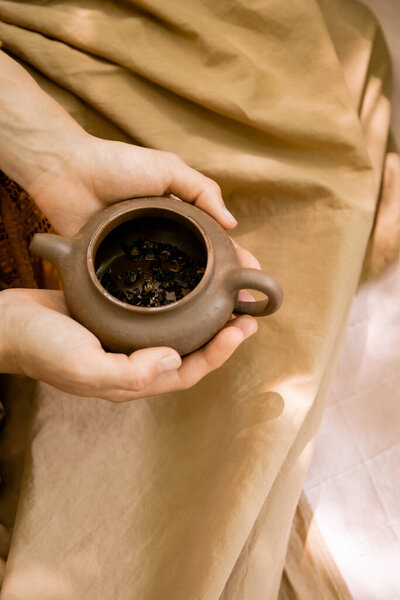 Top view of woman holding teapot with tea outdoors 