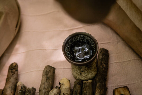 Top view of tea in bowl on stone on blanket outdoors 