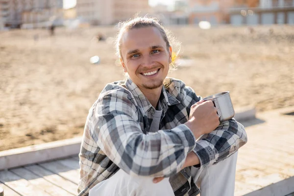 Homme gai tenant tasse sur jetée sur la plage à Trévise — Photo de stock