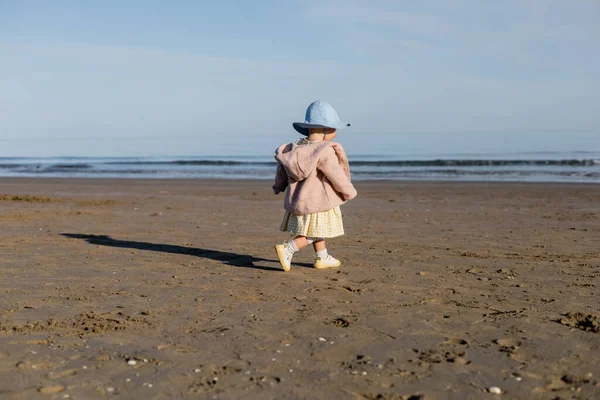 Bébé fille en chapeau panama marchant sur la plage en Italie — Photo de stock