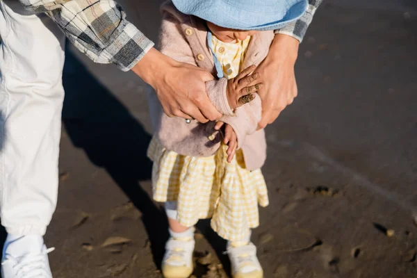 Man holding hands of baby daughter on beach — Stock Photo