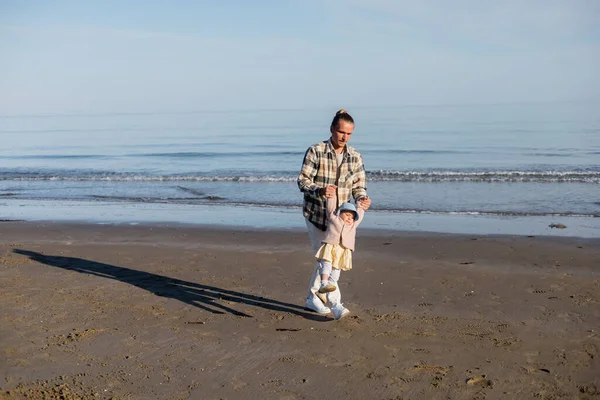 Padre che gioca con la bambina sulla spiaggia vicino al mare Adriatico in Italia — Foto stock