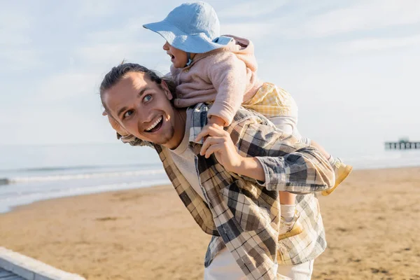 Joven padre divirtiéndose con su hija en panama sombrero en la playa en Treviso - foto de stock