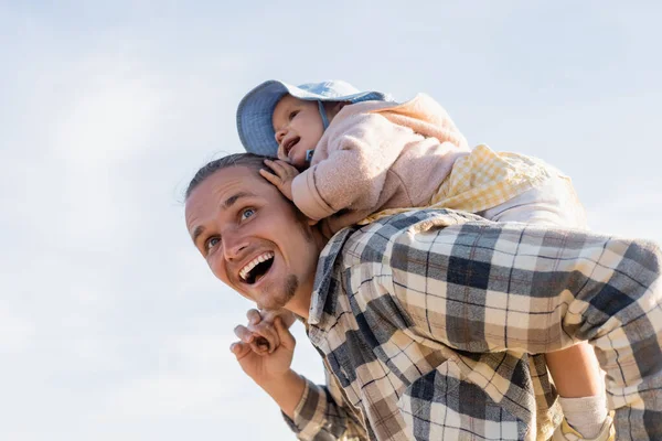 Low angle view of positive father and baby girl having fun with sky at background — Stock Photo