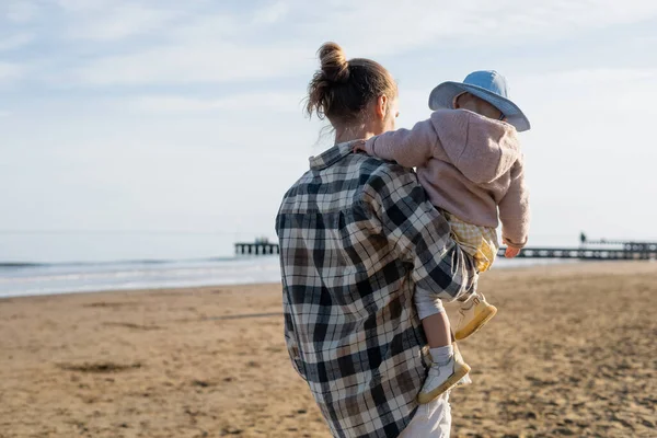 Father carrying baby daughter on blurred beach in Treviso — Stock Photo