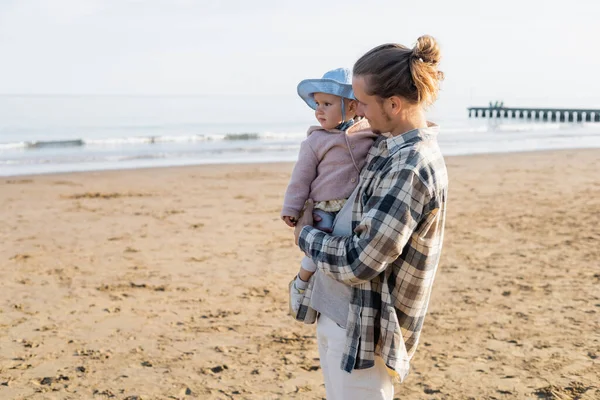 Genitore guardando figlia in cappello panama sulla spiaggia di Treviso — Foto stock