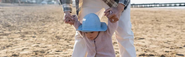 Uomo che si tiene per mano del bambino sulla spiaggia, striscione — Foto stock