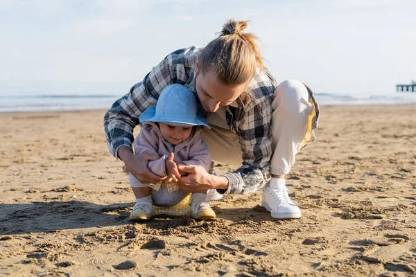 Father and daughter playing with sand on beach in Treviso — Stock Photo