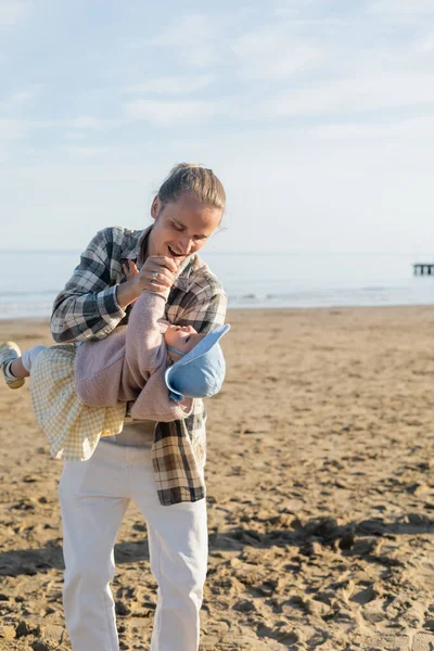 Smiling father playing with baby daughter on beach in Treviso — Stock Photo