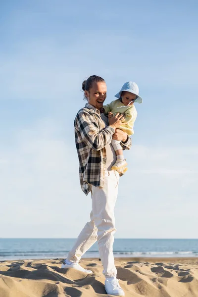 Positiver Vater hält Kleinkind zu Fuß am Strand in Treviso — Stockfoto