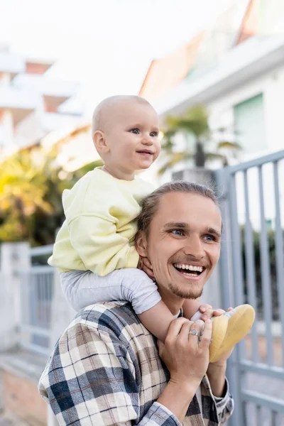Portrait of young man holding smiling baby girl on urban street in Treviso — Stock Photo