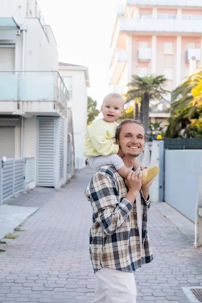 Man holding smiling baby girl on urban street in Treviso — Stock Photo