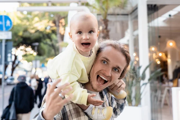 Возбужденные отец и ребенок глядя вдаль на городской улице в Тревизо — стоковое фото