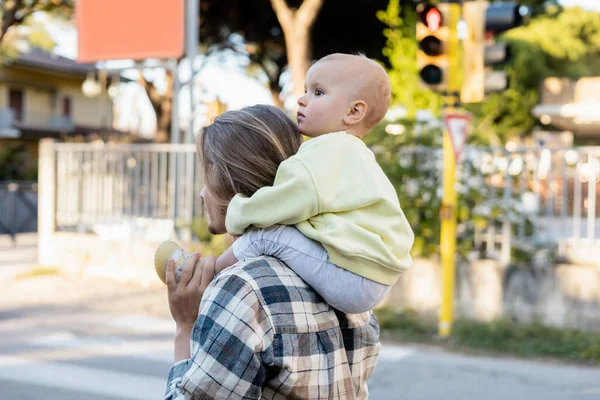 Man carrying baby girl on shoulders on urban street in Treviso — Stock Photo