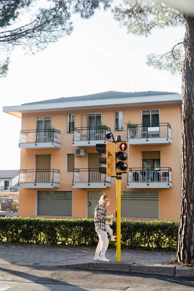 Young man holding toddler daughter near traffic light on urban street in Treviso — Stock Photo