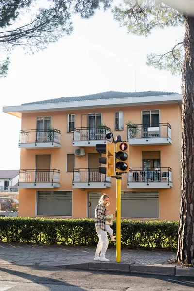 Jeune homme tenant fille tout-petit près des feux de circulation dans la rue urbaine de Trévise — Photo de stock