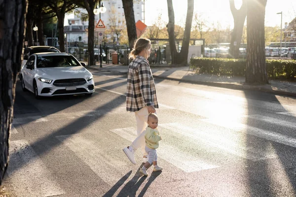 Father and toddler girl walking on crosswalk on urban street in Treviso — Stock Photo