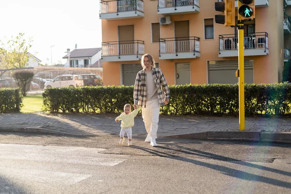 Positive father and toddler child walking on crosswalk outdoors in Treviso — Stock Photo