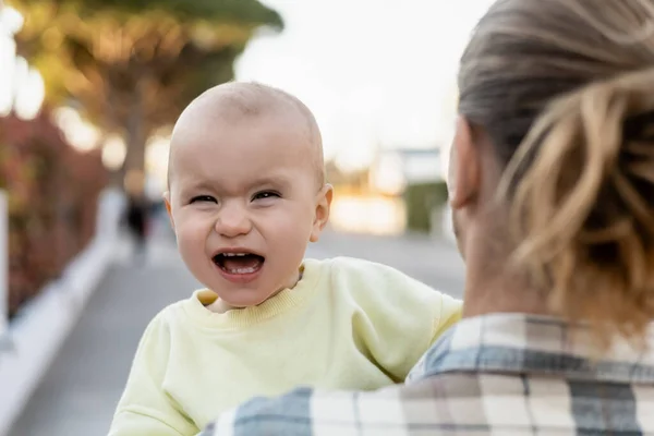Baby girl with open mouth looking at camera near dad outdoors — Stock Photo
