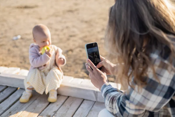 Размытый отец фотографирует дочь малыша на пляже в Тревизо — стоковое фото