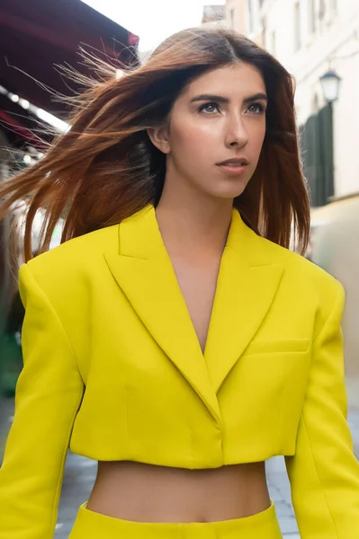 Young redhead woman in yellow crop jacket on blurred street in Venice — Stock Photo