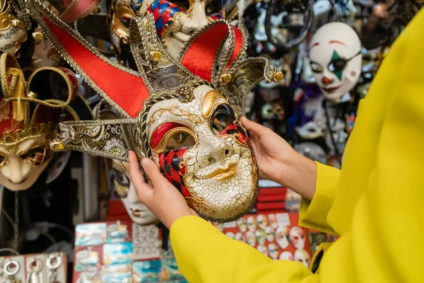 Частковий вид на жінку, що тримає барвисту карнавальну маску у Венеції. — стокове фото