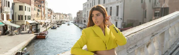 Stylische Frau in gelber Crop-Jacke mit Blick auf Brücke über den Canal Grande in Venedig, Banner — Stockfoto
