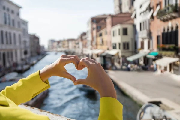 Vue recadrée de la femme montrant signe cardiaque à Venise sur fond flou — Photo de stock