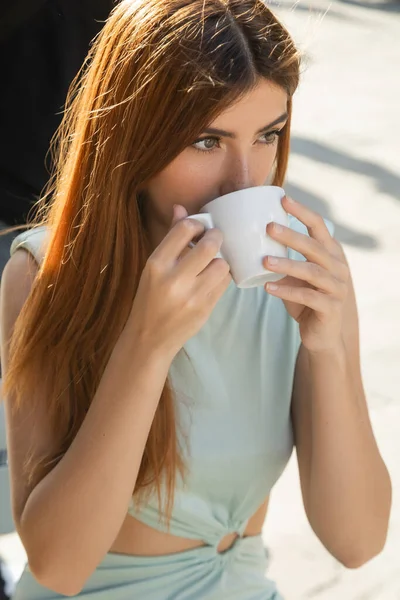 Mulher com cabelo vermelho olhando para longe enquanto bebe café em Veneza — Fotografia de Stock