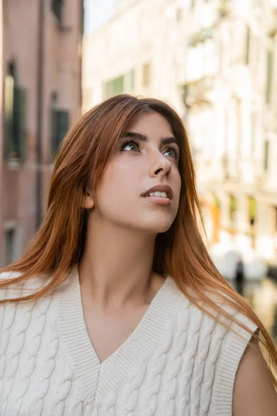Retrato de una joven pelirroja mirando hacia otro lado sobre un fondo borroso en Venecia - foto de stock