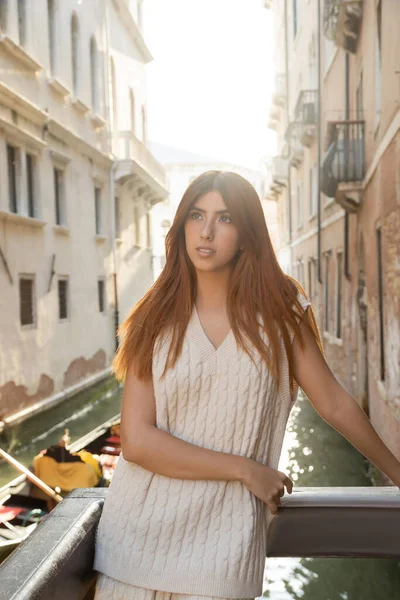 Encantadora pelirroja en ropa de punto de verano mirando hacia otro lado en Venecia sobre fondo borroso - foto de stock