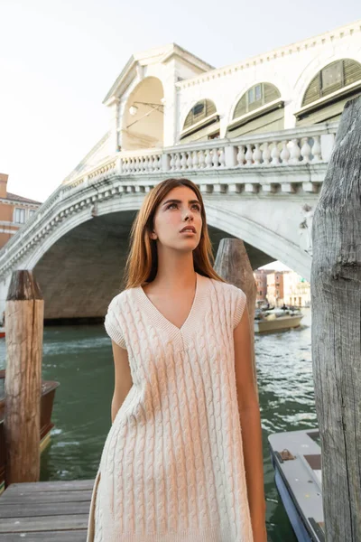 Вродлива жінка в безрукавному стрибуні, яка дивиться у далечінь біля Міста Ріальто у Венеції. — Stock Photo