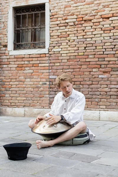 Street musician playing handpan near hat in Italy — Photo de stock