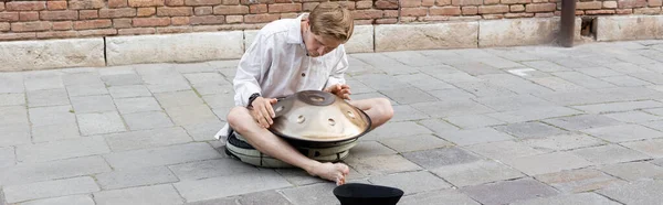 Musician playing hang near hat on sidewalk in Venice, banner — Stock Photo