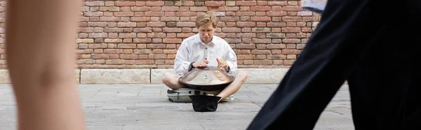 Man performing hang near hat on sidewalk on urban street in Venice, banner — Stockfoto