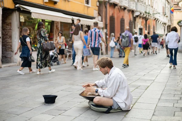 VENICE, ITALY - MAY 22, 2022: Street musician playing hang near hat on urban street — Stock Photo