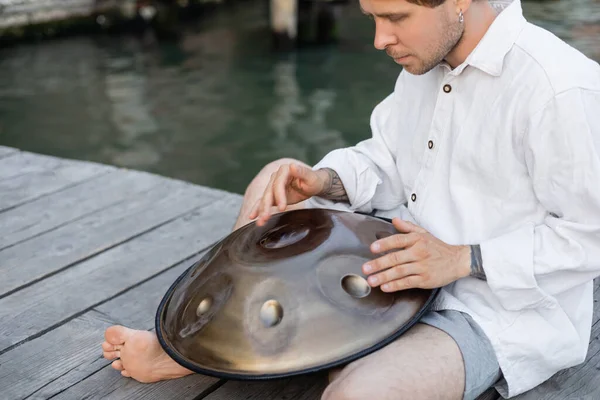 Musicista scalzo che suona il tamburo appeso al molo a Venezia — Foto stock