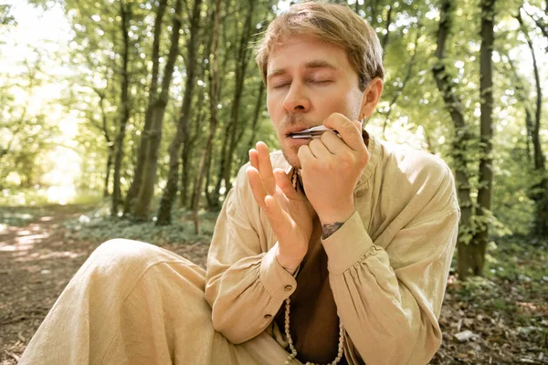 Man playing vargan in blurred forest — Stock Photo