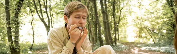 Musician playing jews harp in blurred summer forest, banner — Stock Photo