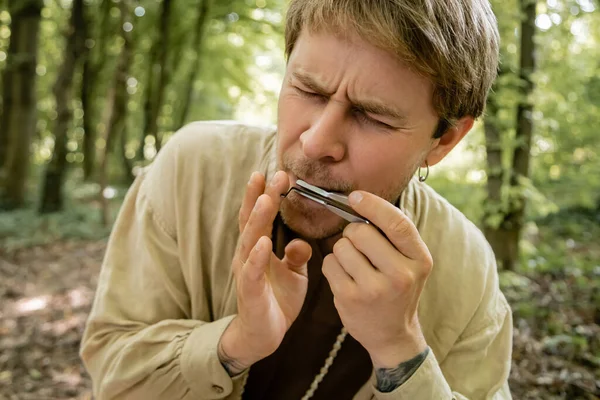 Tätowierter Mann spielt Judenharfe im Wald — Stockfoto