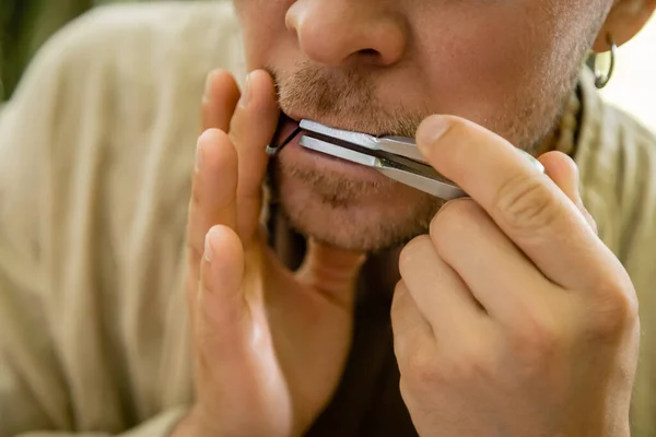 Cropped view of man playing jews harp outdoors — Stock Photo