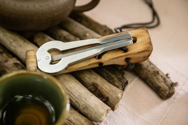 Jews harp near teapot on wooden board — Stock Photo