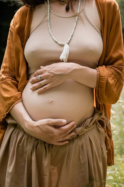 Vue recadrée de la femme enceinte touchant le ventre dans le champ — Photo de stock