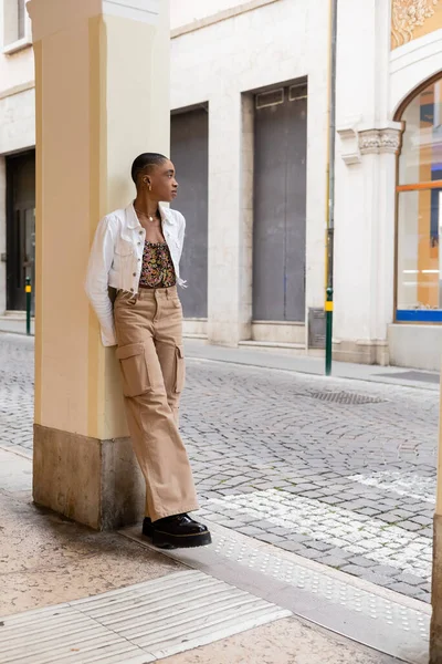 Seitenansicht eines kurzhaarigen afrikanisch-amerikanischen Reisenden, der auf einer städtischen Straße in Treviso steht — Stockfoto