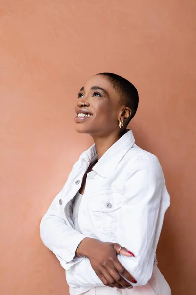 Portrait de femme afro-américaine aux cheveux courts souriant debout près du mur — Photo de stock