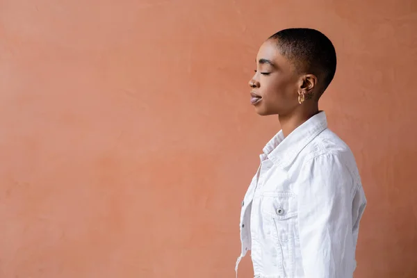 Vue latérale de la femme afro-américaine à la mode debout près du mur — Photo de stock