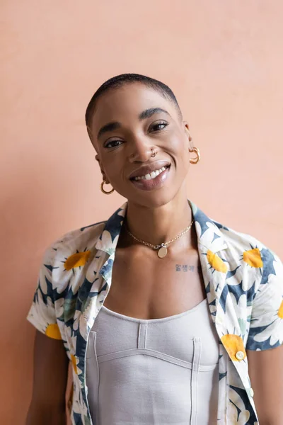 Portrait de femme afro-américaine souriante regardant la caméra près du mur — Photo de stock